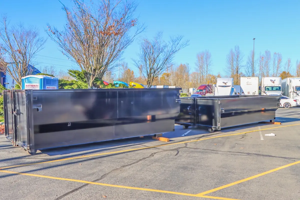 Professional dumpster rental service with roll-off container on residential driveway in Oak Island